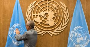 Un home col·loca una bandera de l'Organització de les Nacions Unides
