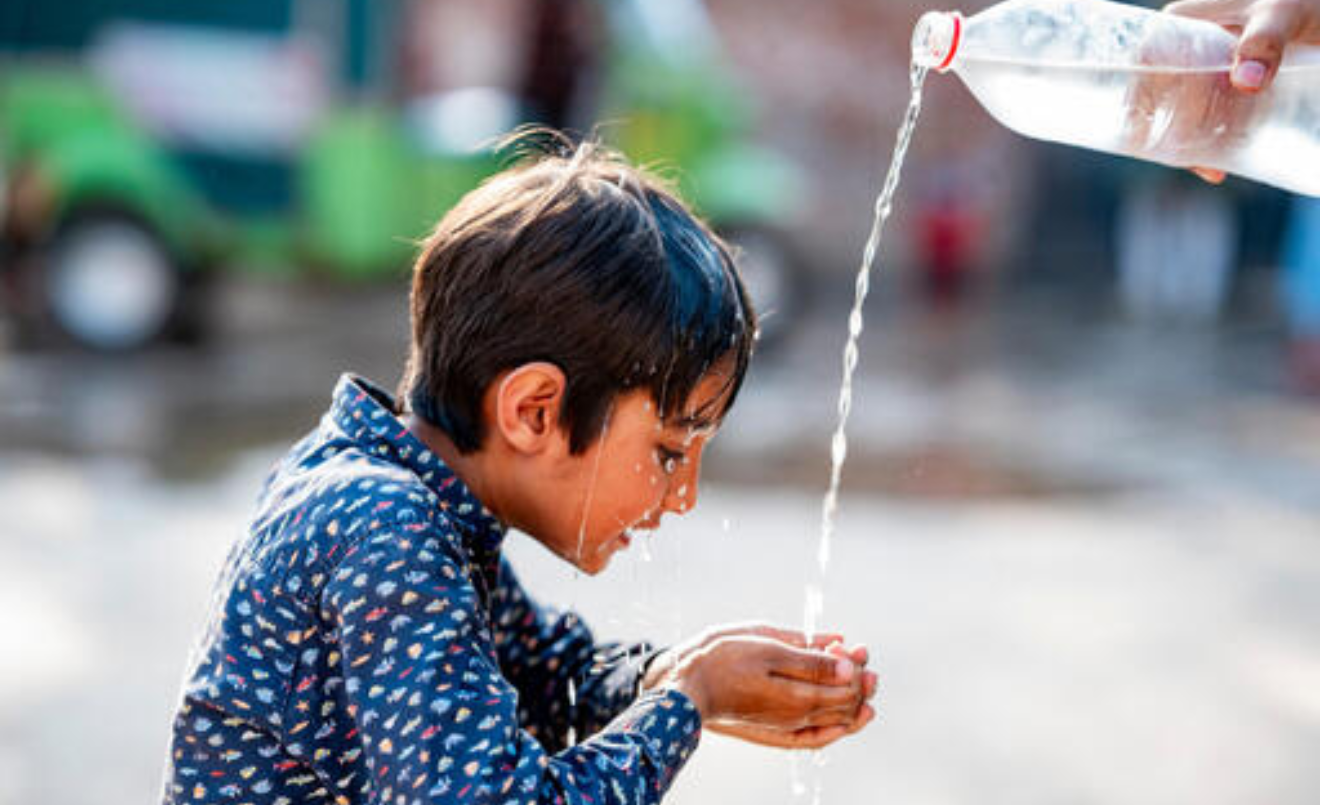 Un nen refrescant-se al Pakistan, un país que fa front a una sequera cada cop més greu (UNICEF/UNI585293/Khalid)